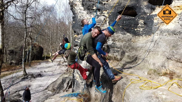 Slaňování s postiženým, kdy záchranář pospíchá zahájit první pomoc.